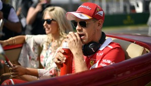 Vettel wird bei der Fahrerparade vor dem Rennen von einer Blondine kutschiert. Wirklich interessieren tut das den Ferrari-Star aber offenbar nicht ...
