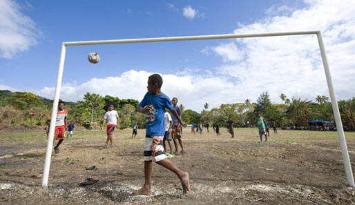 Kinder beim Fußballspielen auf einem Bolzplatz auf dem Inselstaat Vanuatu