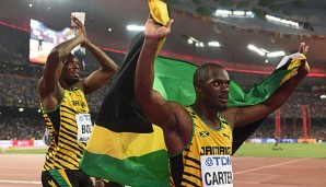 Bolt (l.) wird wegen einer positiven Doping Probe bei Carter (r.) sein Peking-Gold-verlieren