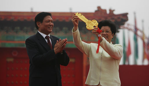 Liu Qi, die OK-Präsidentin, übergibt dem Bürgermeister des Dorfes, Chen Zhili, den Schlüssel