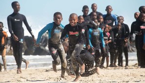 Am Strand von Kapstadt toben die Jungs beim Waves for Change-Projekt