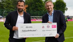 FC-Bayern-Sportvorstand Hasan Salihamidzic und Eckhard Sauren, Vize-Präsident 1. FC Köln, präsentieren die gemeinsame Spende für Flutopfer.