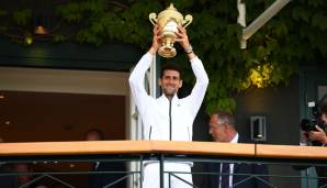 Novak Djokovic präsentiert seinen Pokal auf dem berühmten Südbalkon von Wimbledon.